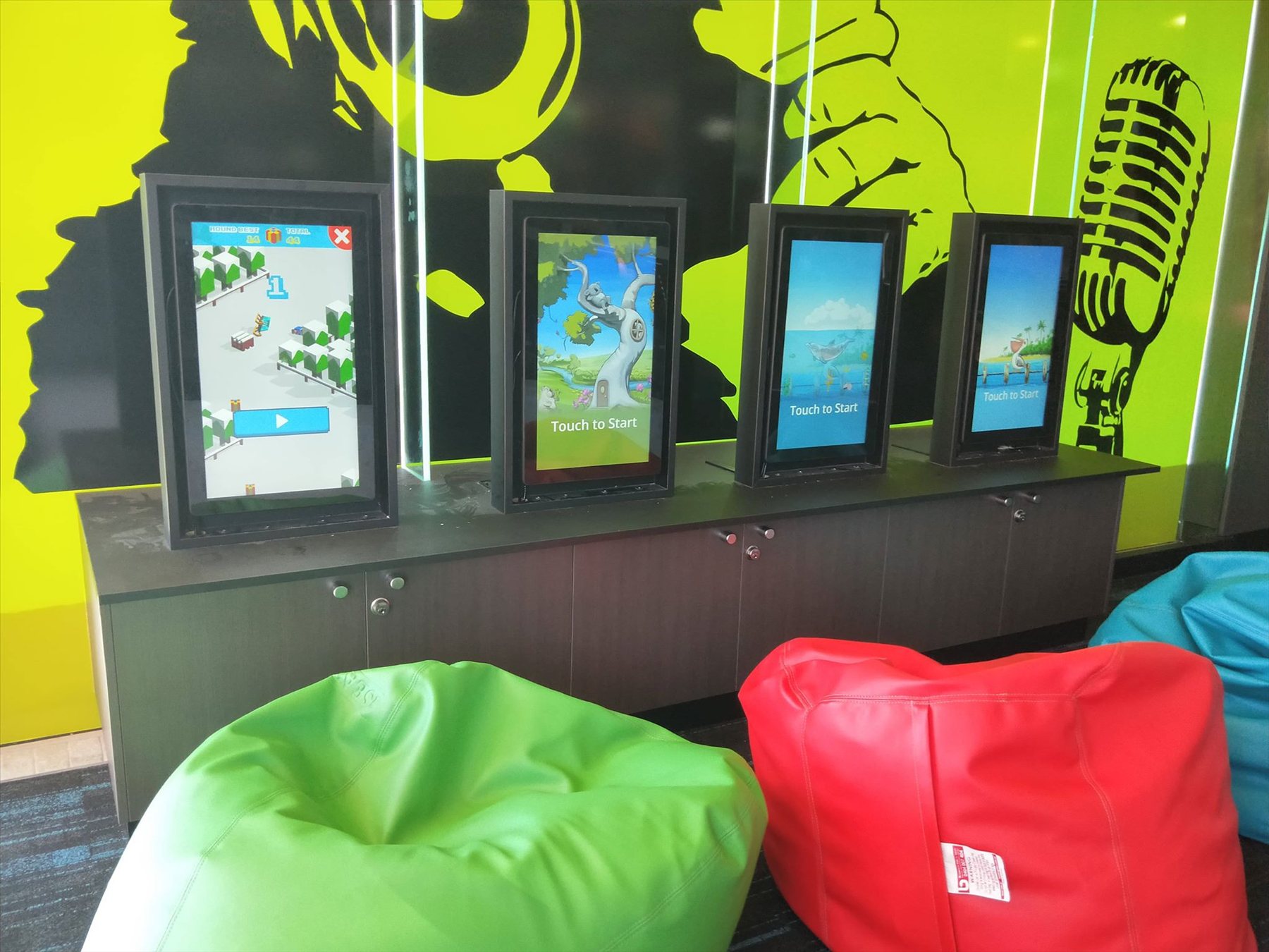 Row of kids game screens with colourful bean bags at Geelong RSL