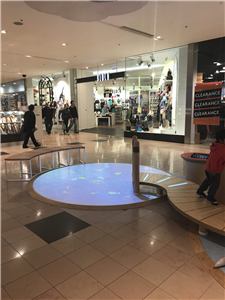 A circular interactive floor and bench seating in a play area at Chadstone Shopping Centre