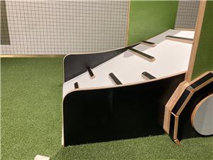 A close view of a black tractor play ramp on artificial grass