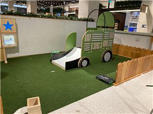 A farm-themed play space with a star sign, tractor slide and picket fence