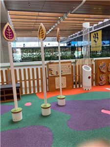 A play area with picket fence, leaf-shaped signs and coloured rubber flooring