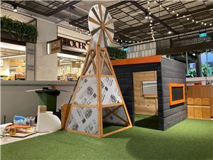 A windmill and barn play house in a farm-themed play area under construction