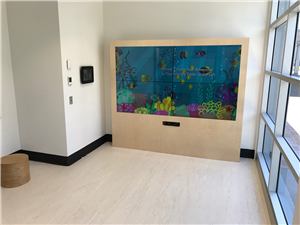 A large video wall of an underwater scene in a children's room at the Kids Research Institute