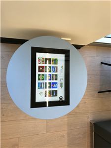 A circular wall frame holding a touch screen of children's games