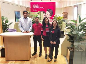 Four Medibank staff standing beside the reception counter in a new store
