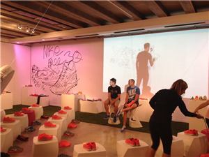 A Nike Training Club event with an artist's drawing projected on a wall and shoes on stools