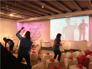 A Nike activation with guests at tables and an interactive projection on the wall