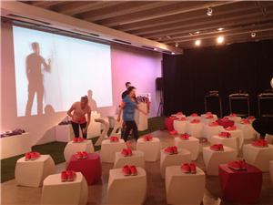 A Nike event with shoes on white stools and a projection wall