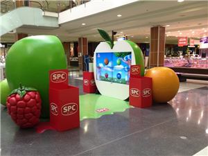 A giant apple, orange and raspberry SPC display in a shopping centre