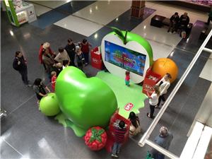 A crowd looking at the SPC apple interactive video wall from above