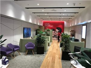 A Medibank store interior with a red feature wall and seating