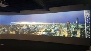 A wide projection of a night city skyline in a sales suite