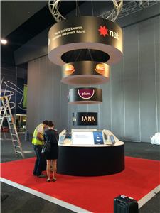 A NAB exhibition stand with a round interactive table and hanging rings
