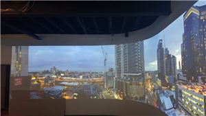 A wide night city skyline projected on a curved wall