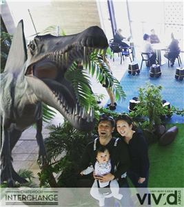 A family photo with a large dinosaur at the Chatswood Interchange activation