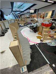 A play area under construction with timber fencing and a pink marked path