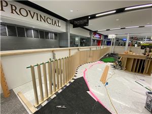 A play area being built with timber fence panels and floor markings