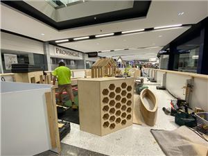 A timber play area with a honeycomb panel and a boat being built