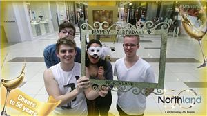 Friends holding a Happy Birthday photo frame in a Northland 50th anniversary augmented reality photo