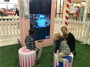 Children talking to Santa on a live video screen with a helper at Northland