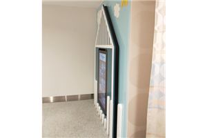 A wall-mounted kids game screen set into a house-shaped frame in the Brandon Park amenities room