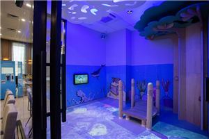 A blue underwater sensory playroom with an interactive floor at The Health Hub