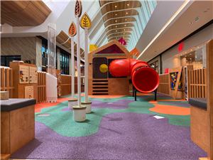 The Grand Central play space with a timber house, red slide and purple play floor